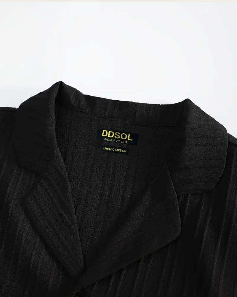 Black garment with a visible brand label on a white background