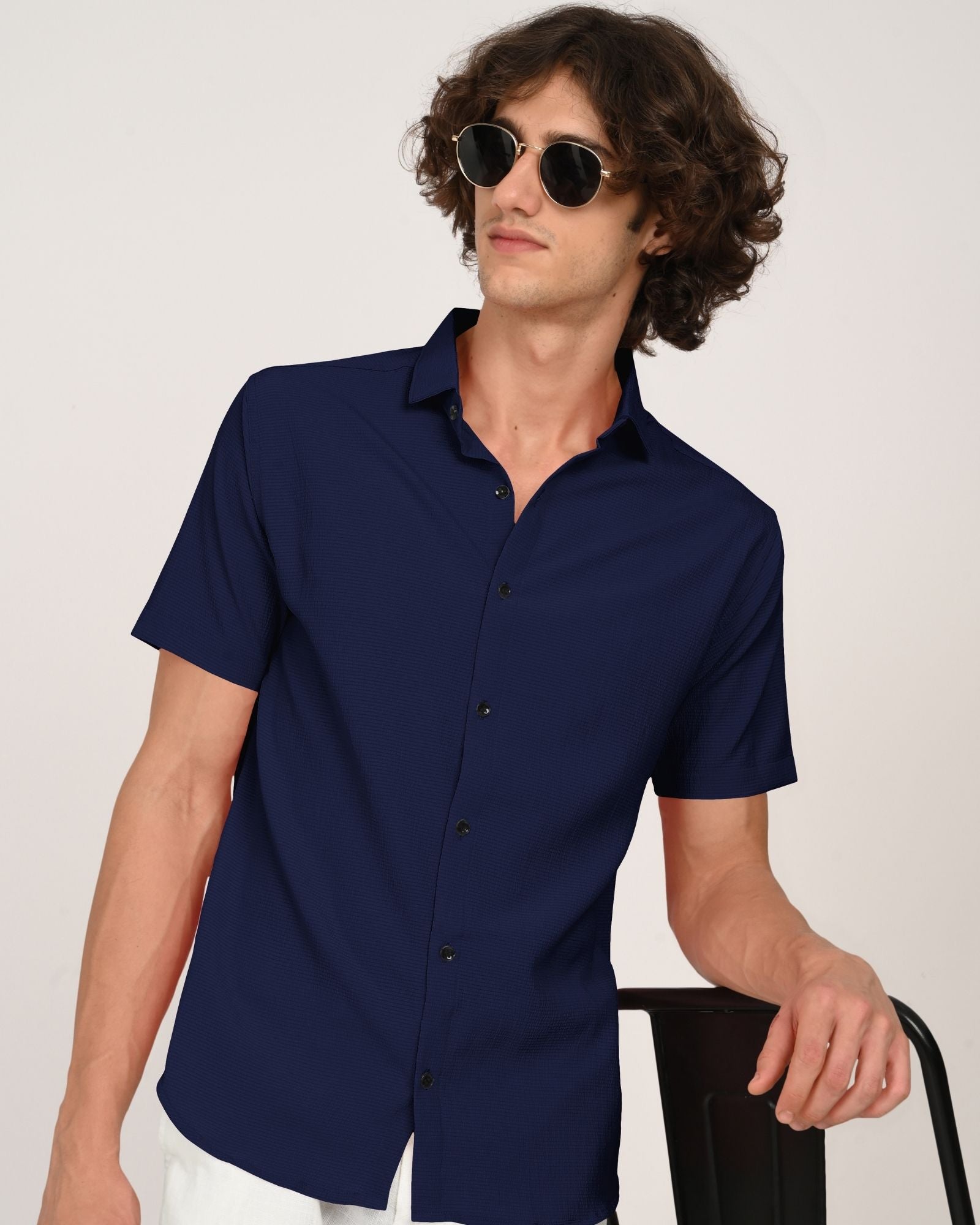 Close-up front angle of navy textured short-sleeve shirt with sunglasses