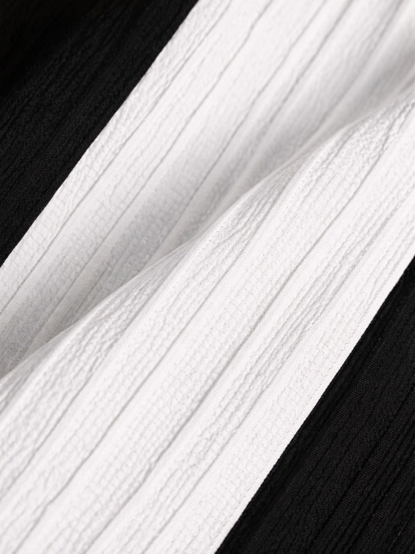 Close-up of black and white contrast panel fabric highlighting lightweight textured material