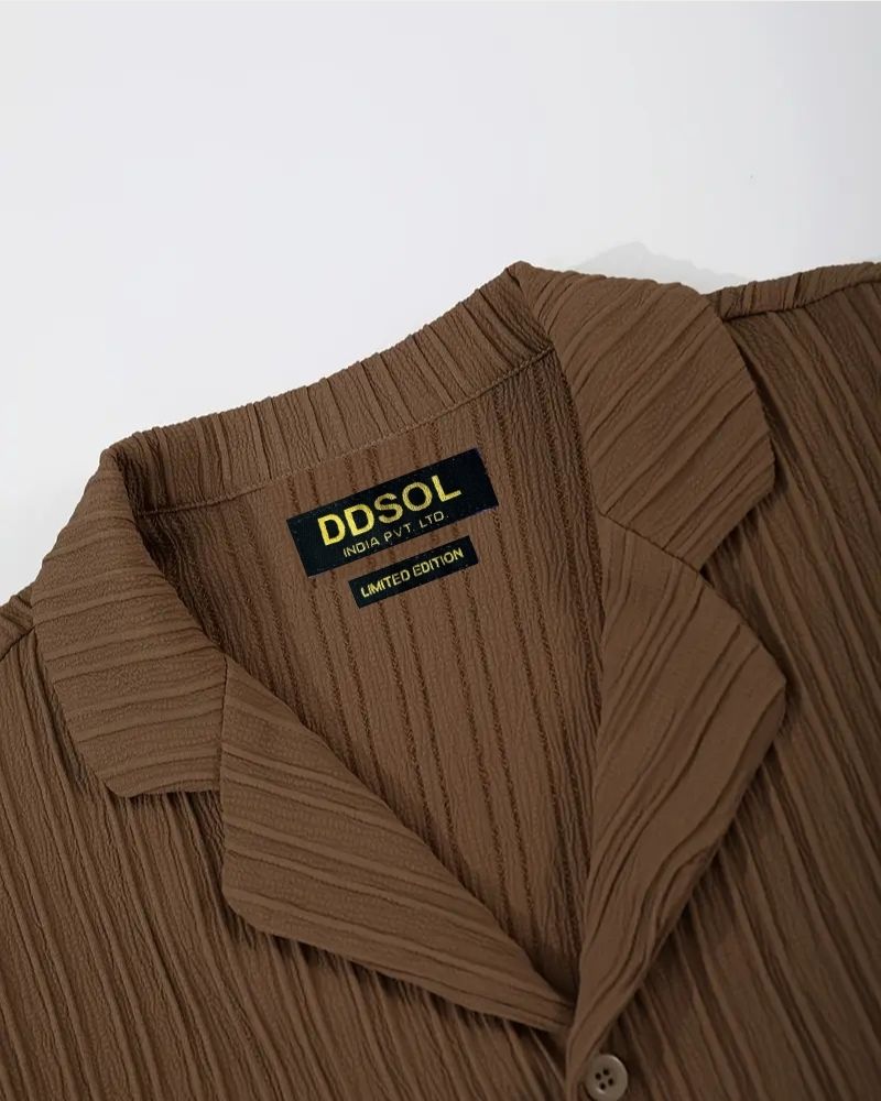 Close-up of collar and DDSOL label on brown textured shirt