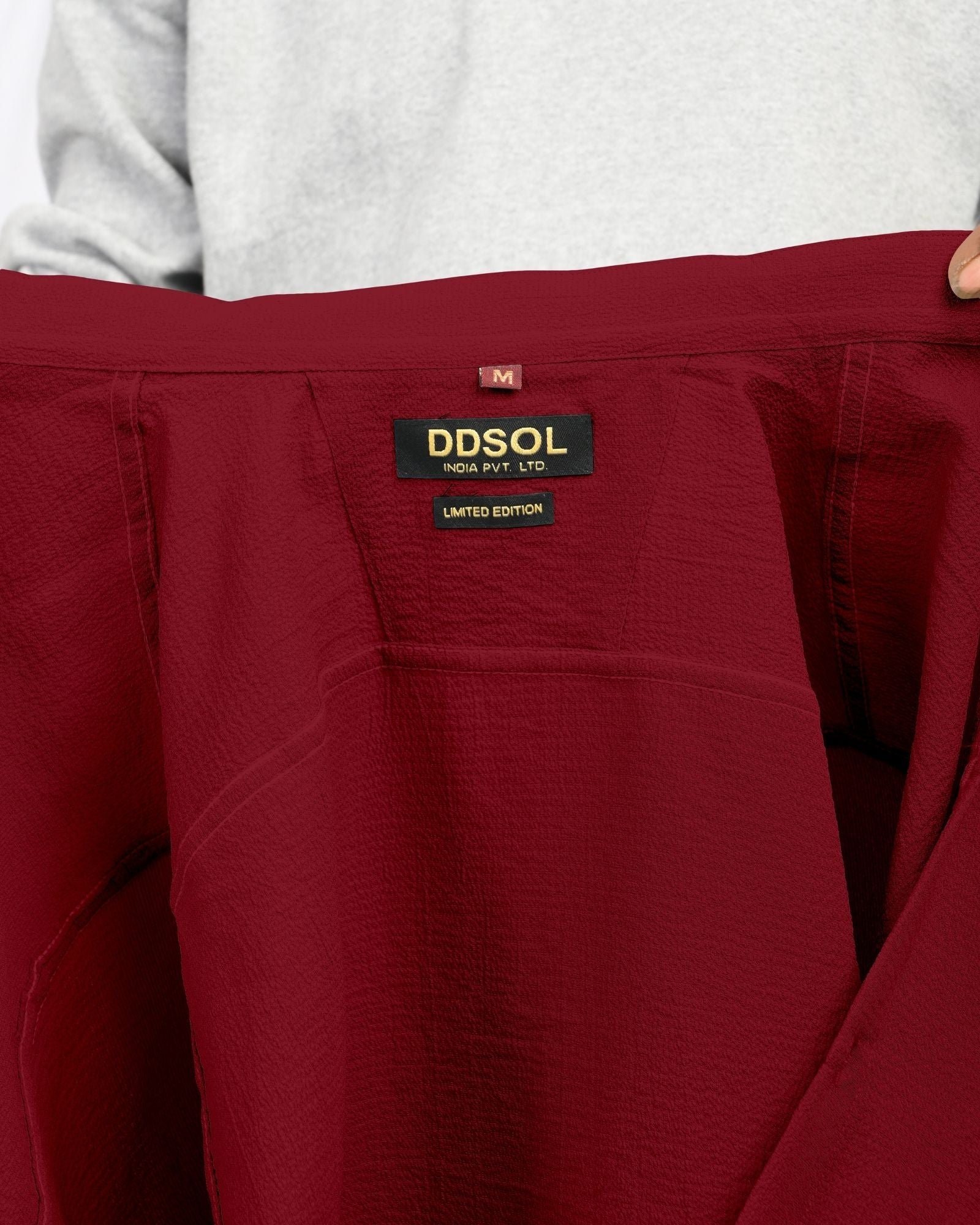Close-up of crimson red short sleeve textured shirt collar and label inside