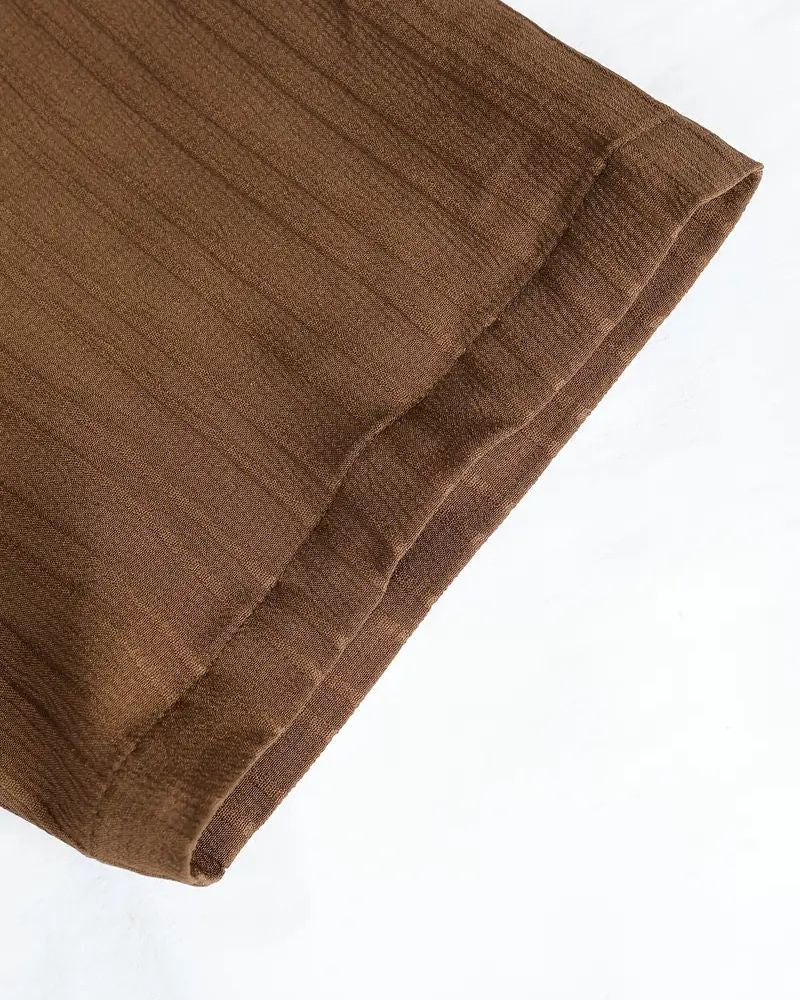 Close-up of finished hem on cocoa cane pleated pants for men