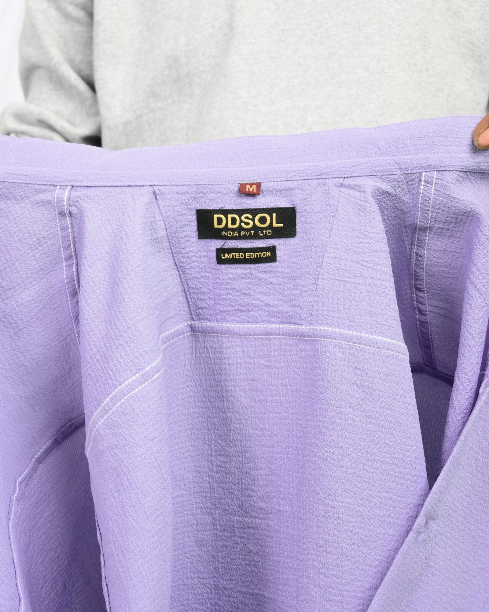 Close-up of lavender shirt label showing DDSOL Limited Edition tag