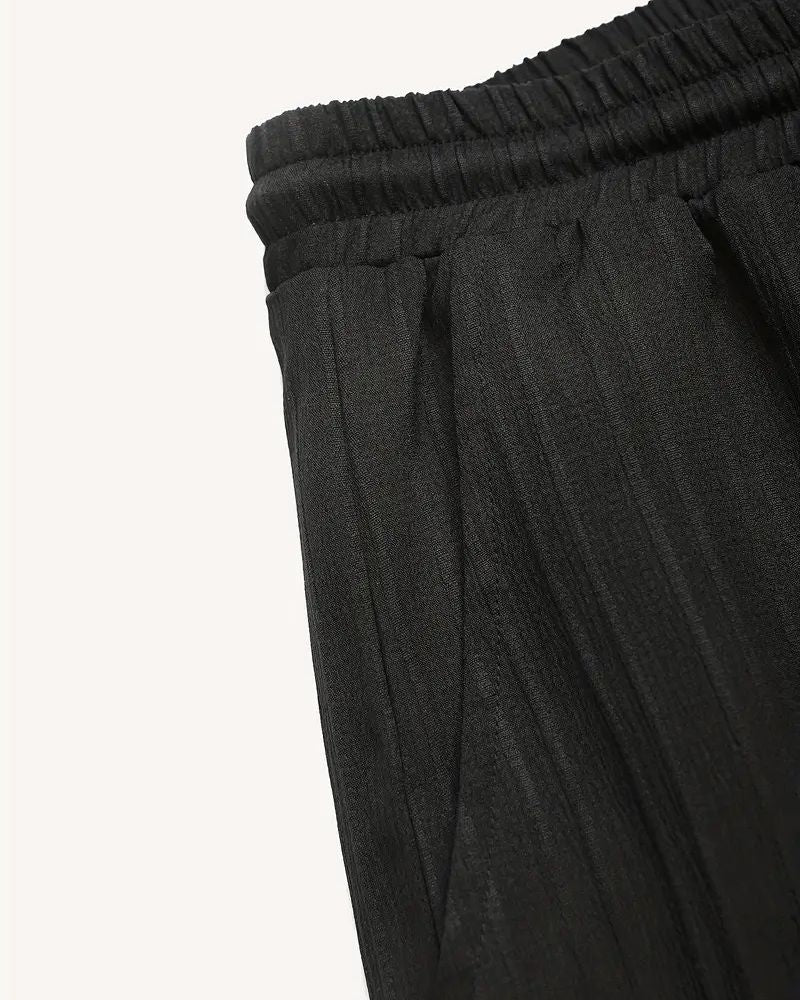 Close-up of side pocket and pleated texture on black men’s trousers