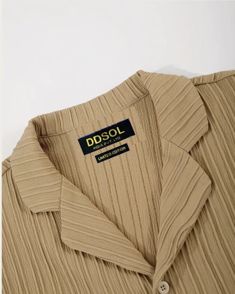 Collar and DDSOL label close-up on beige crinkle shirt