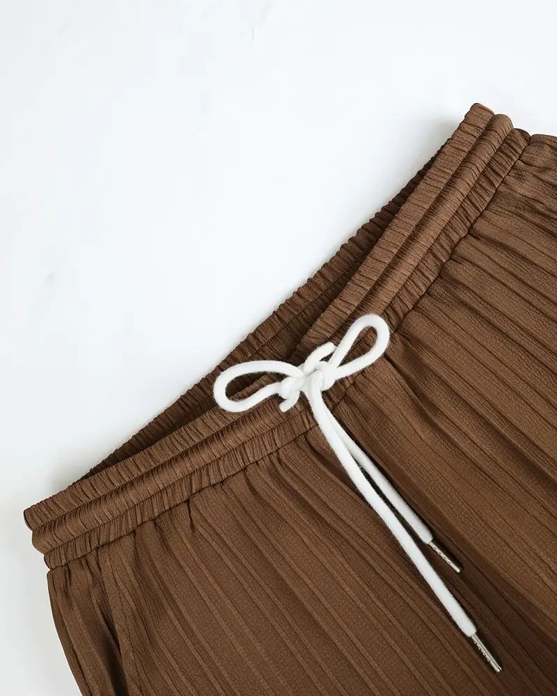 Elastic waistband with white drawstring on brown pleated lounge trousers