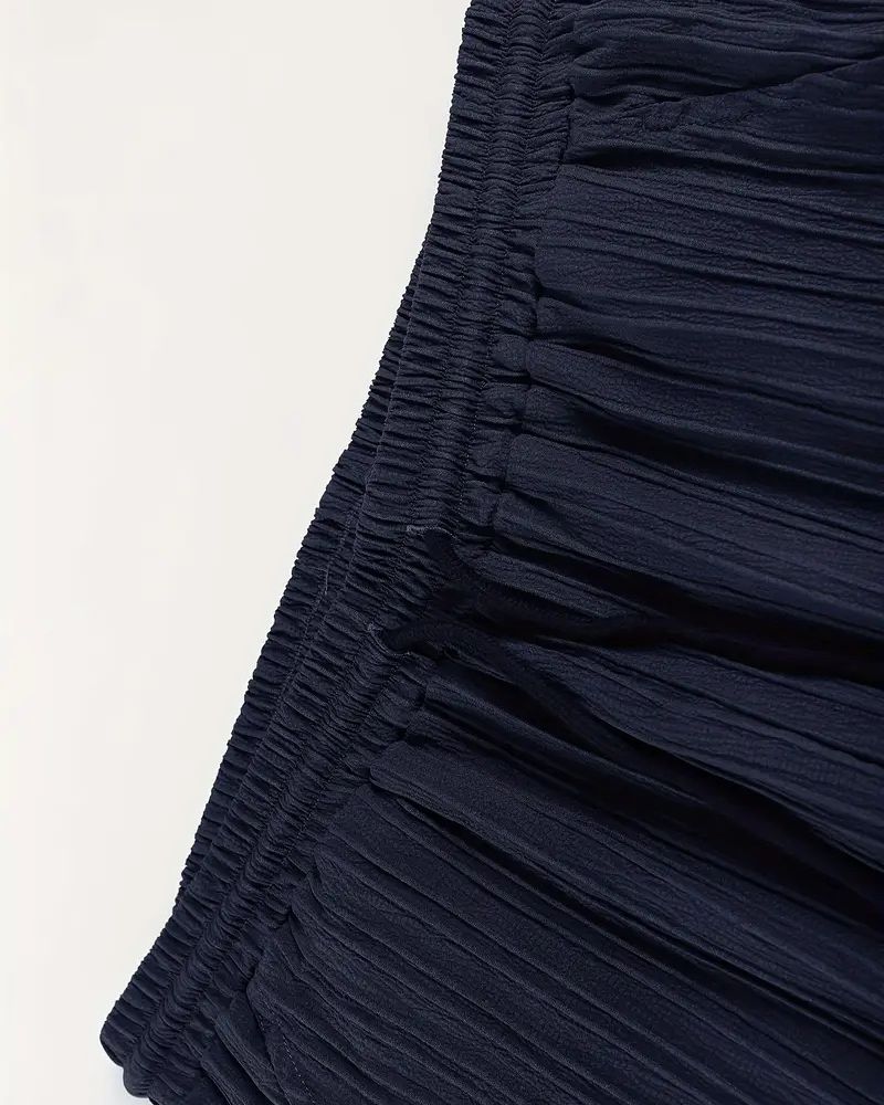 Elastic waistband with white drawstring on lightweight navy pleated pants