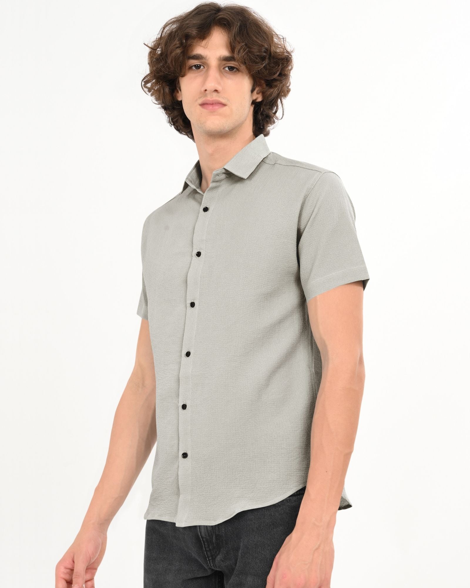 Man wearing grey textured short sleeve button-up shirt, side pose