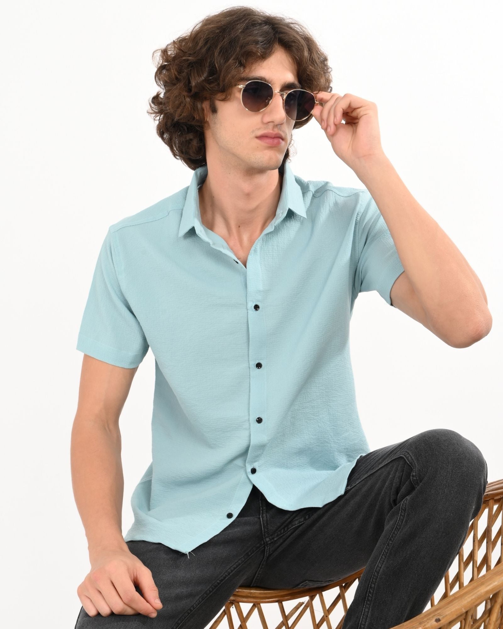 Man wearing light blue textured short sleeve casual shirt with sunglasses