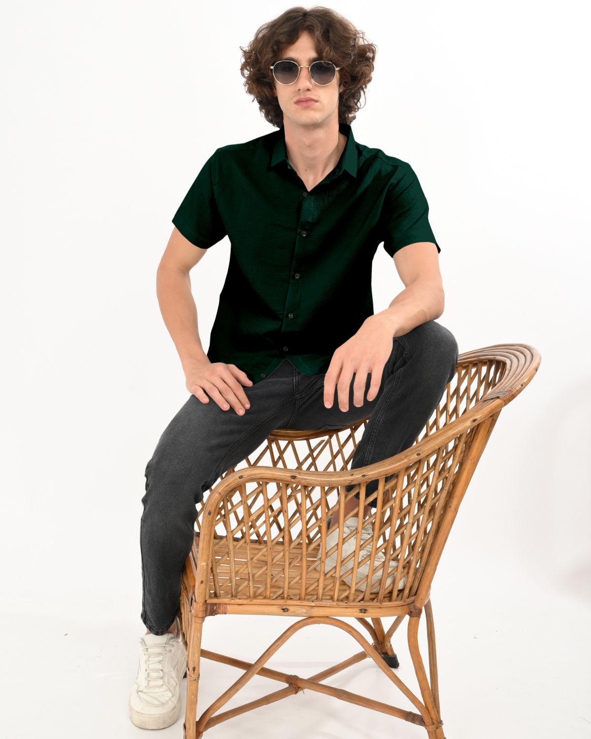 Model sitting wearing dark green textured button down shirt