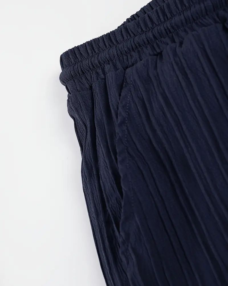 Side pocket and stitching detail of indigo pleated breathable trousers for men