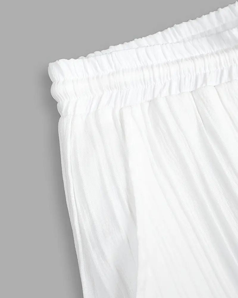 Side view of ivory pleated pants showing waistband and crinkle texture