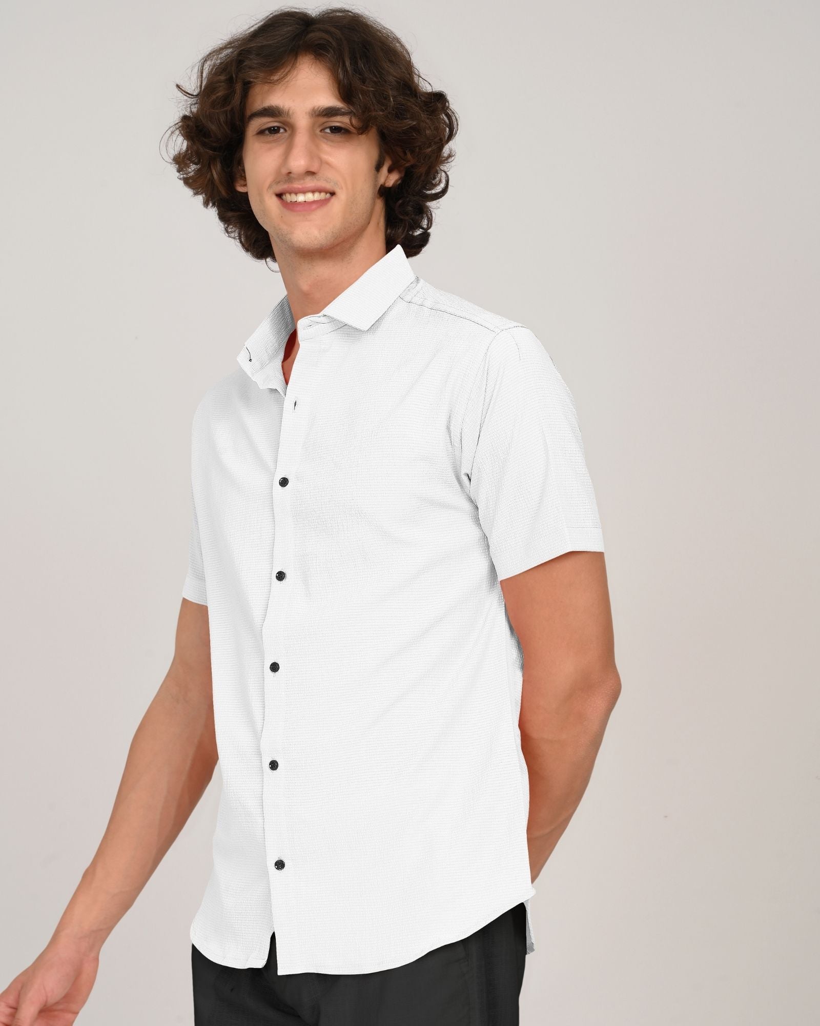 Side view of man smiling in white short sleeve button-down shirt