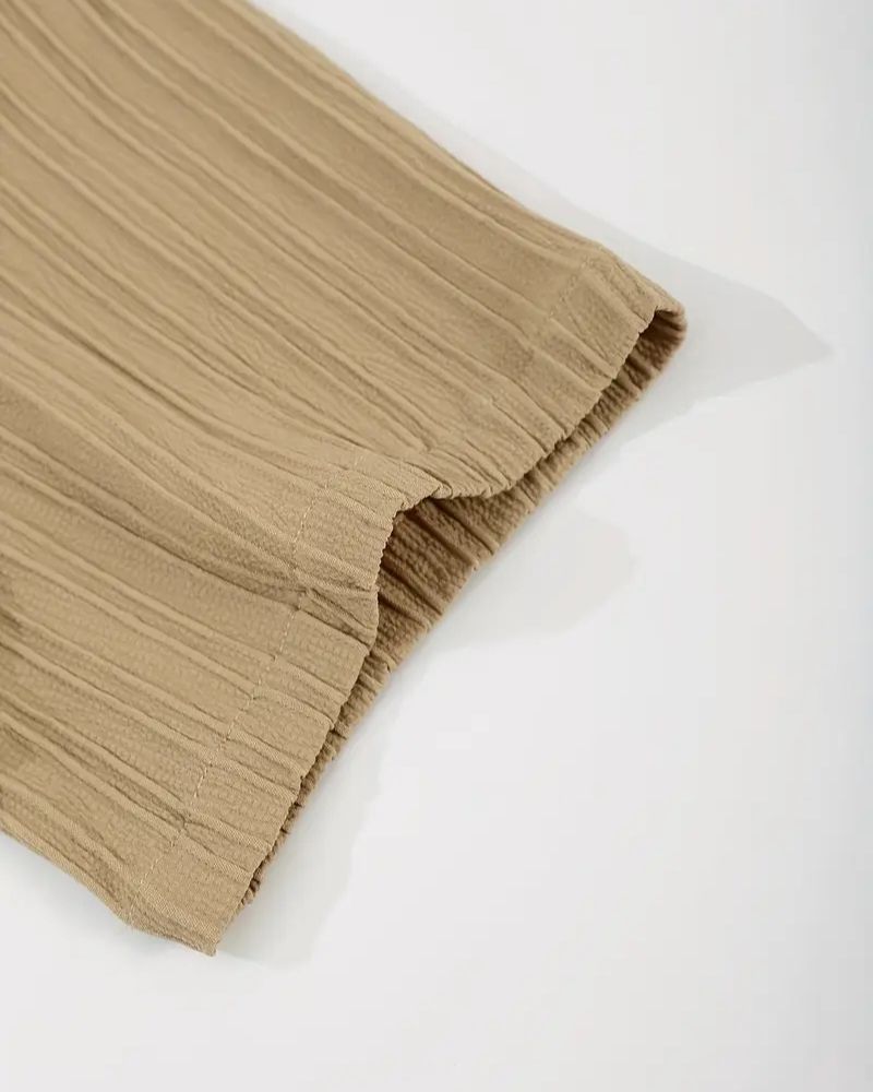 Sleeve hem detail showing crinkle texture of beige shirt