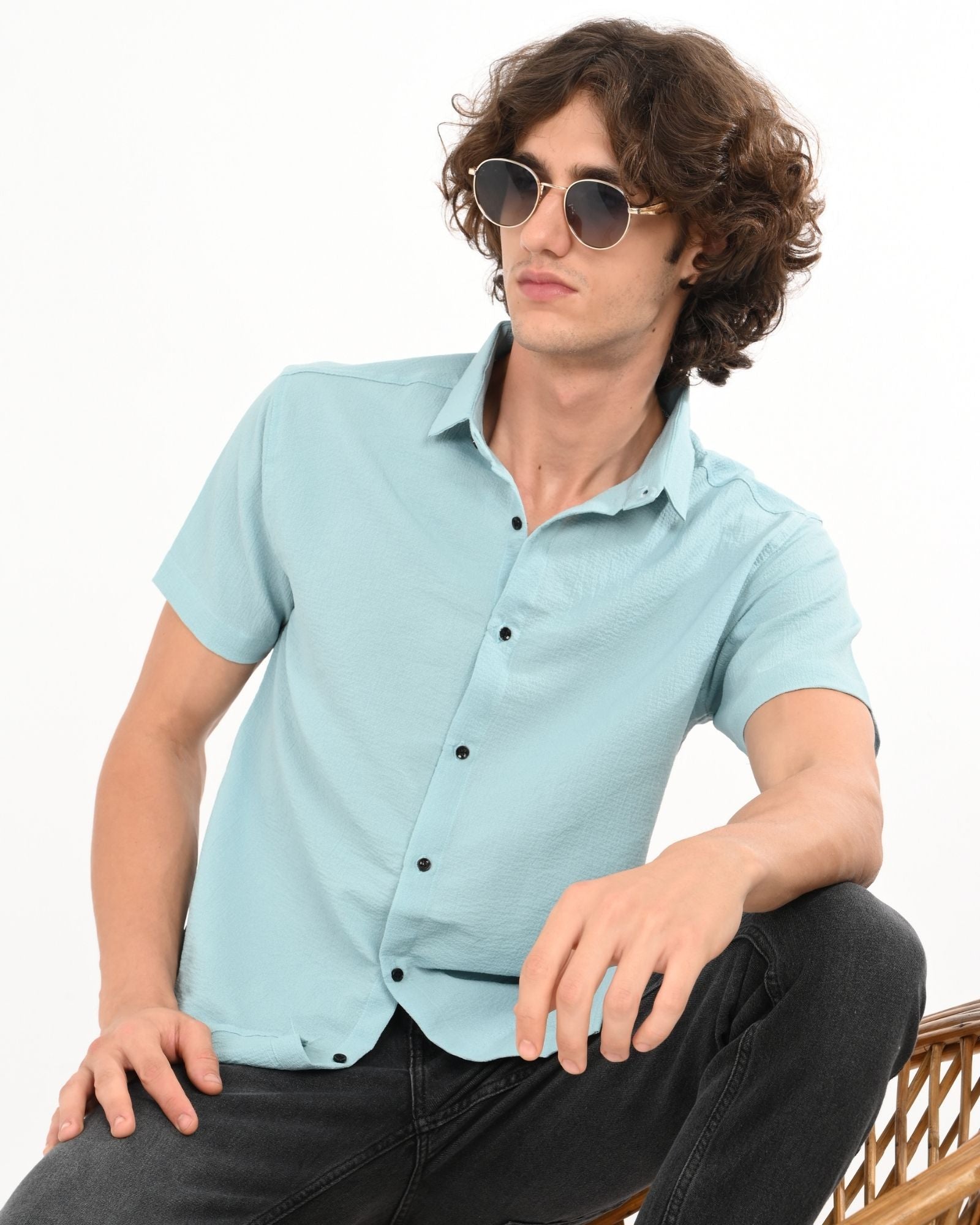 Stylish men’s light blue textured short sleeve button-up shirt, seated pose