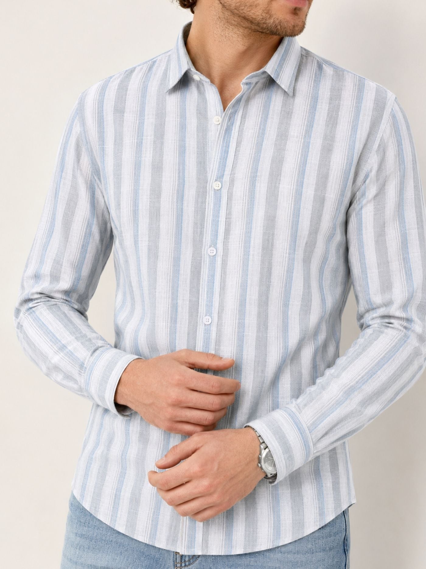 Model wearing Caelum sky blue cotton-rich striped shirt with light-wash jean