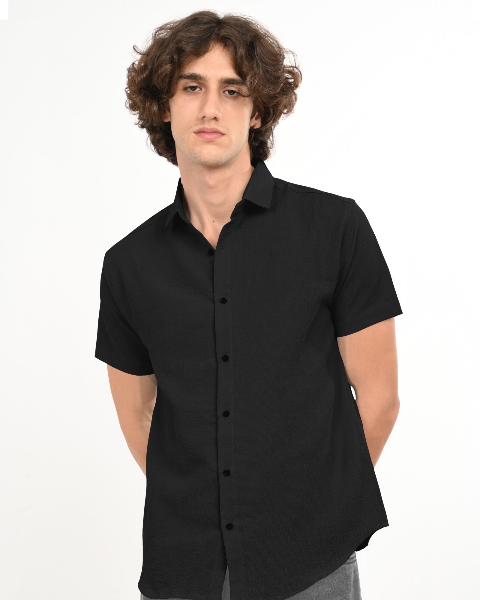 Black textured short-sleeve shirt displayed flat, showing fabric detail