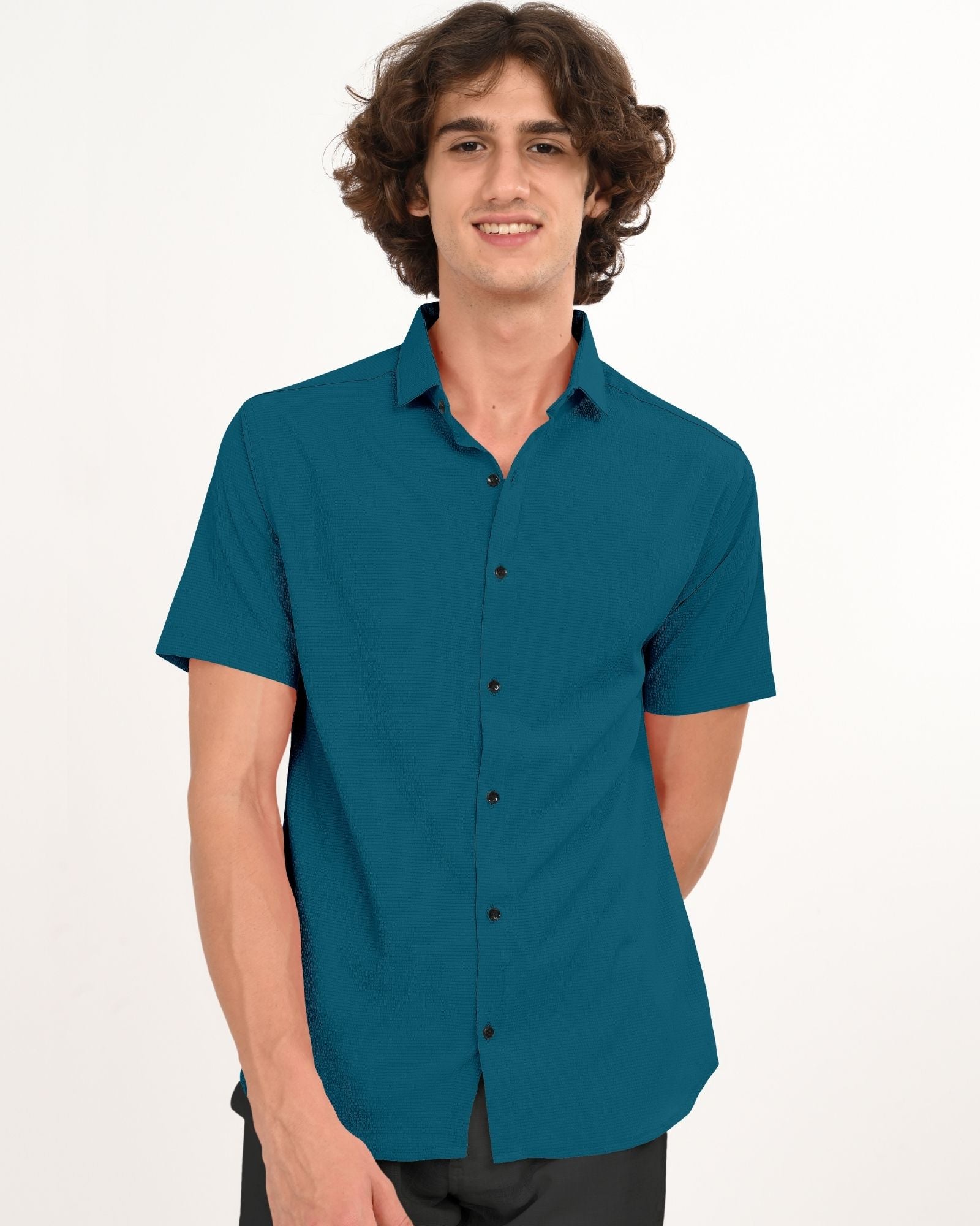 Front view of man wearing teal short sleeve button-down shirt with black buttons