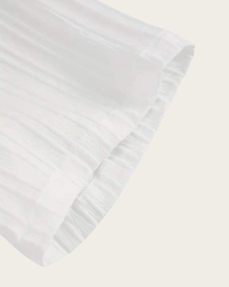 Hem and fabric texture detail of white lounge set sleeve

