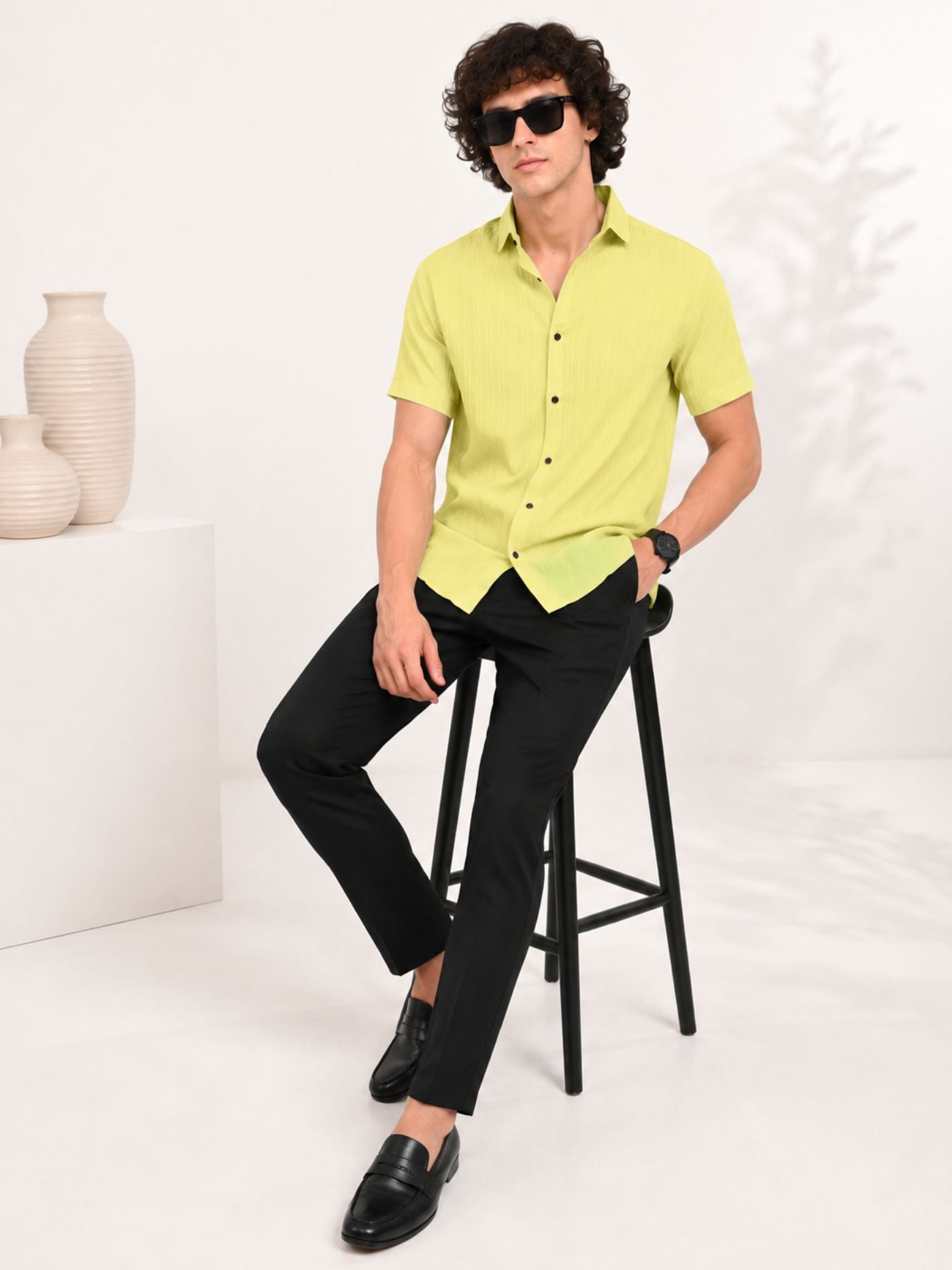 Male model seated on stool wearing Cottonfolk Solace Lime Zest shirt