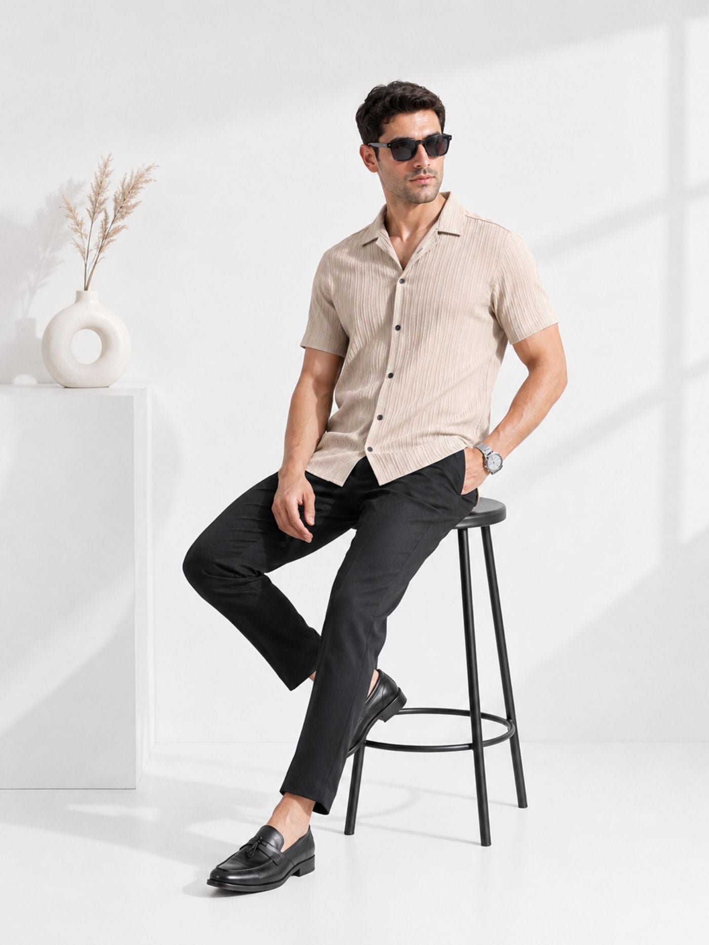 Male model seated on stool wearing Cottonfolk Solace sand beige textured shirt