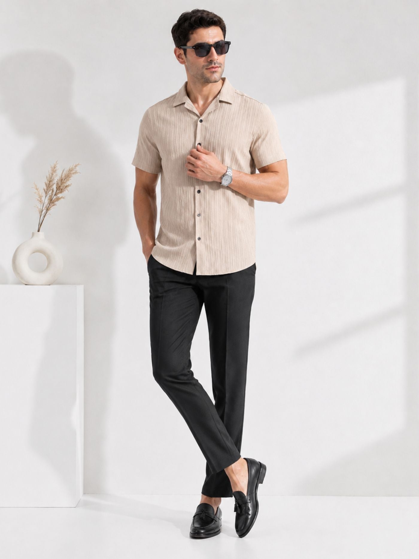 Male model wearing Cottonfolk sand beige resort collar shirt with black trousers