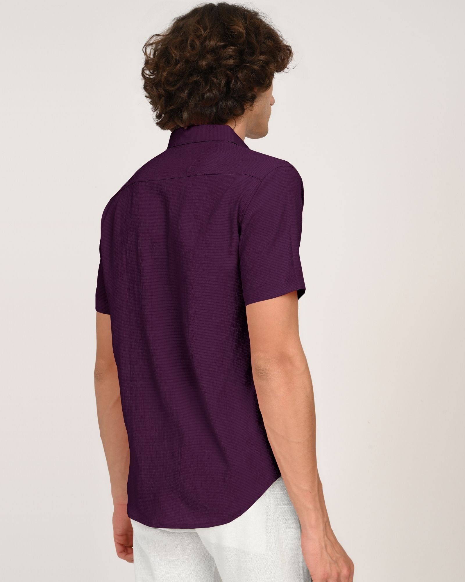 Man showing the back design of the royal plum short sleeve button-down shirt