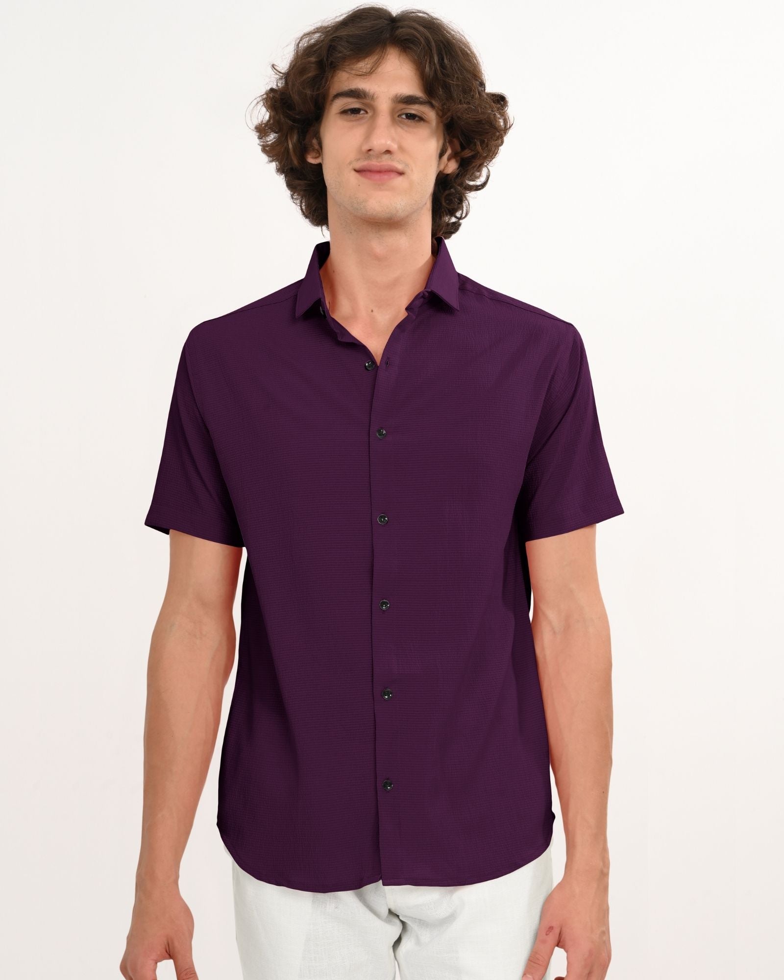 Man wearing a royal plum short sleeve button-down shirt standing straight