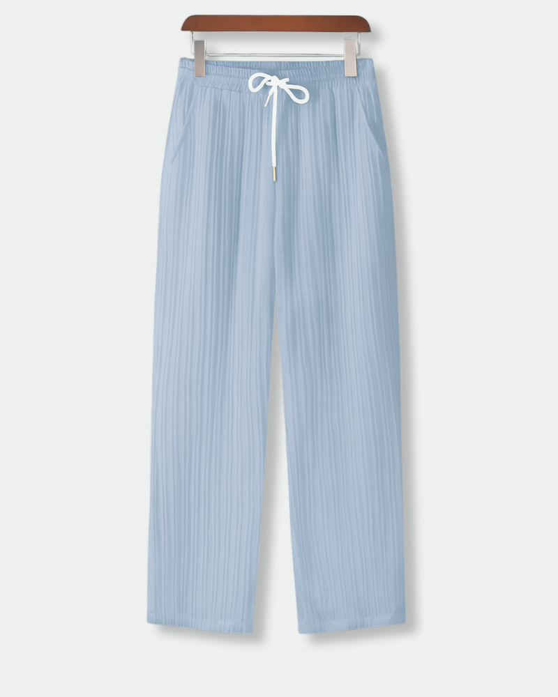 Men's airy fit light blue pleated drawstring trousers hanging on wooden hanger, front view

