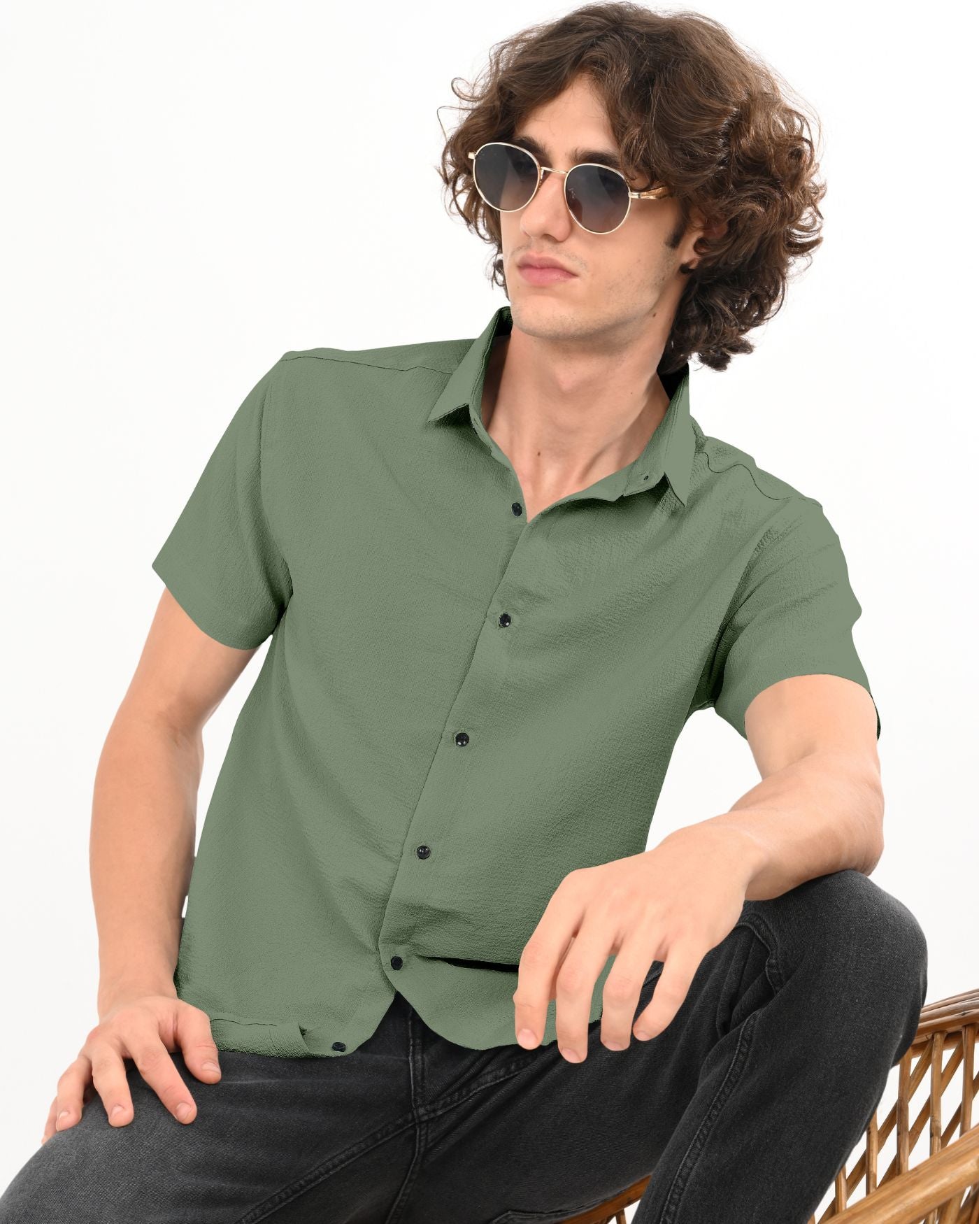 Men’s olive green textured shirt styled with black jeans sitting pose