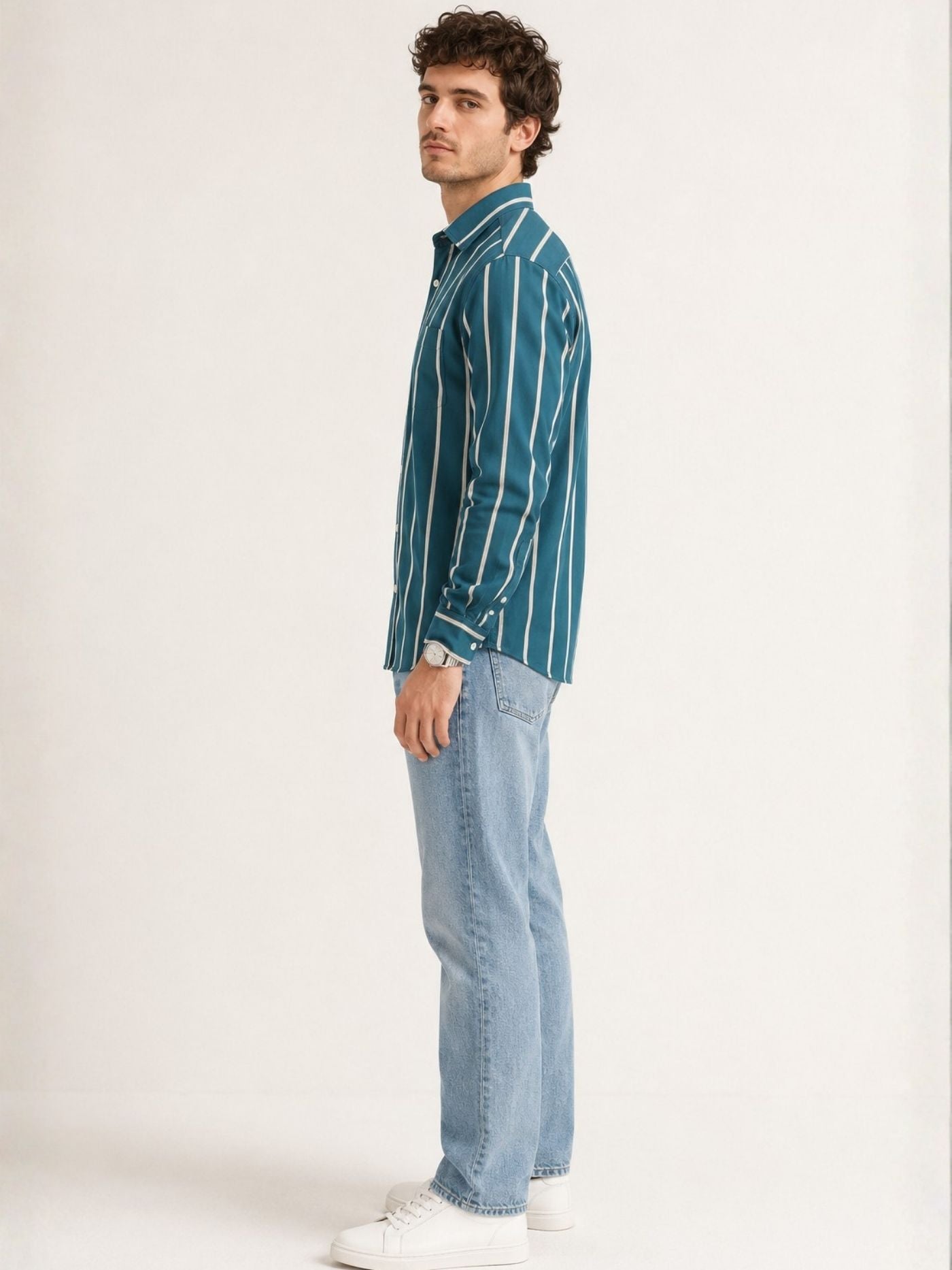 Side profile of Aeron deep teal striped shirt styled with light blue jeans
