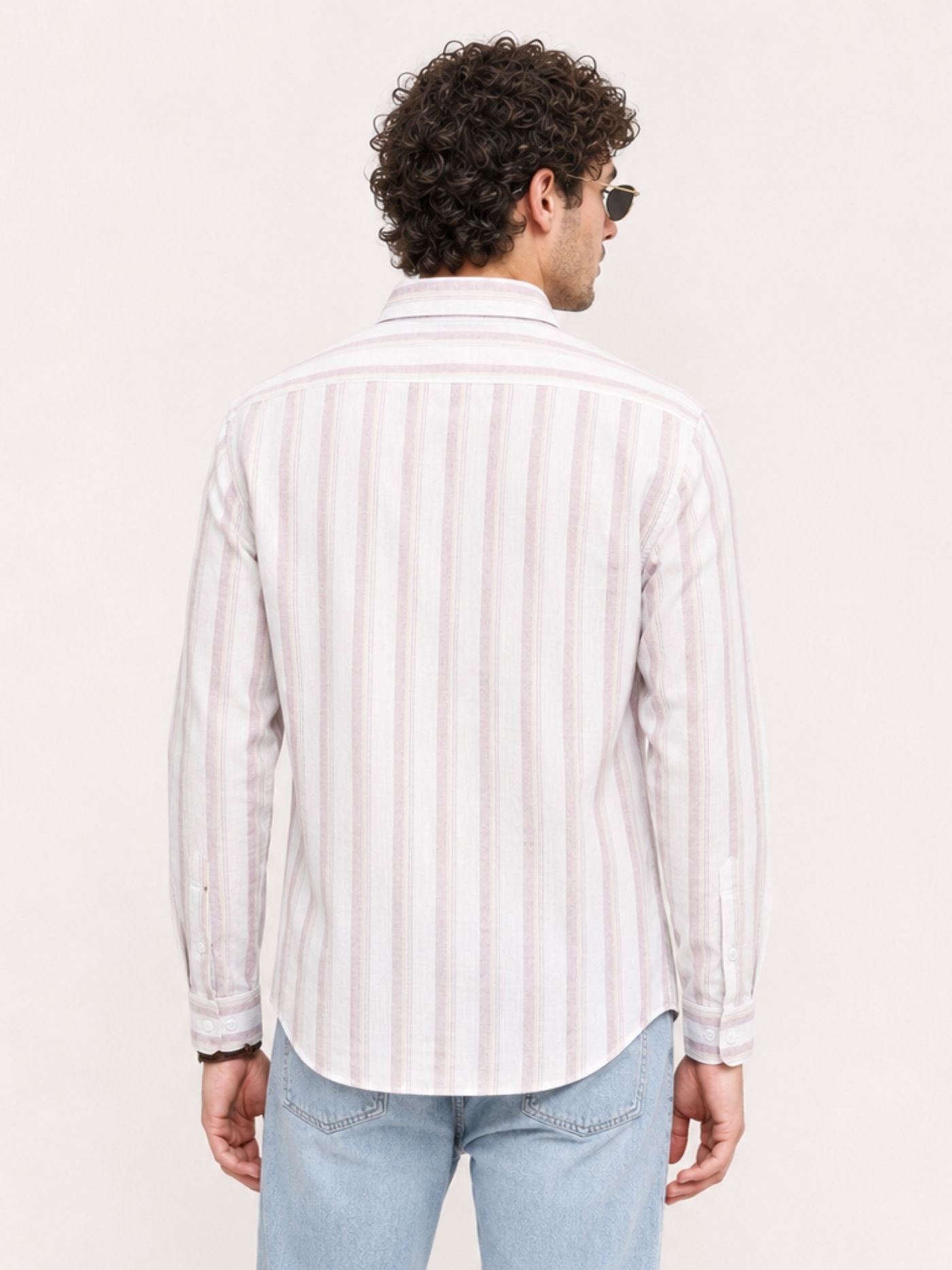 Men’s blush pink and white striped shirt styled with light blue jeans
