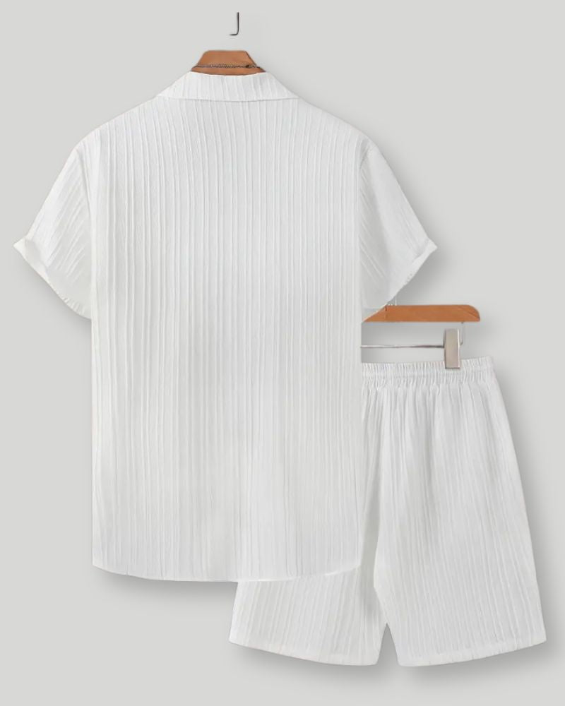 White striped shirt and shorts set on hangers against a light gray background