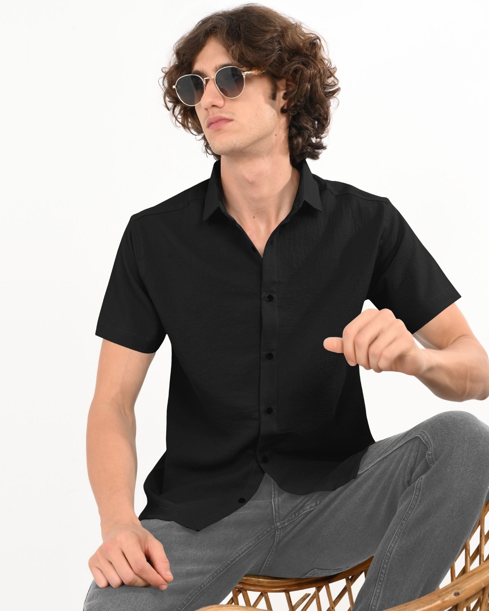 ide angle of black textured short-sleeve shirt, showing curved hemline