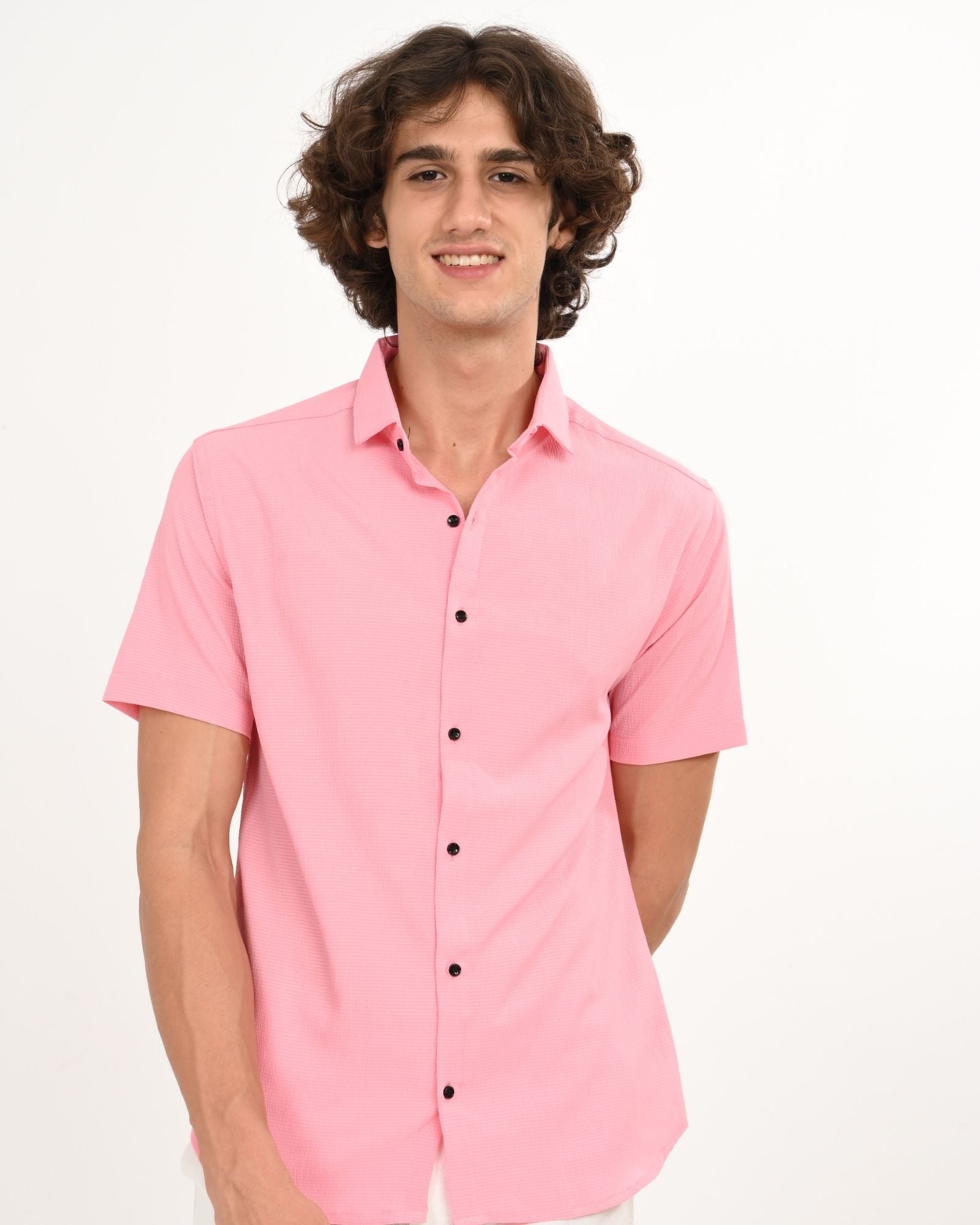 light pink short sleeve button-down shirt with black buttons, front view.